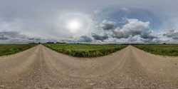360 hdr panorama on no traffic yellow sand gravel road among fields with overcast sky with white clouds and halo in equirectangular spherical projection, VR AR content.  seamless
