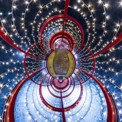abstract circular orb in festively lit underground passage tunnel with red frame arch