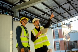 Civil Engineer and Construction Supervisor inspect the internal constructions of building at construction site. Construction engineers or architect and Foreman inspect the construction inside building