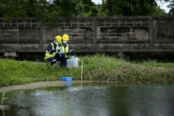 Environmental researchers investigate the condition of canal water for toxic spills, river waste water sampling, Asian researchers collect water samples in farmland for research and development.