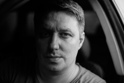 Portrait of a man in a car close-up in black and white tones. Monochrome photo. Low key.