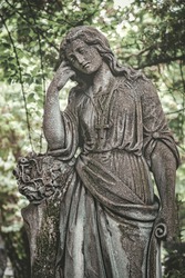 beautiful old tombstone. stone statue of grieving woman, sad angel. background for condolence, mourning cards or obituary.