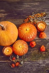 pumpkins and candles on wooden rustic background. autumn composition. cozy fall season. Symbol of thanksgiving holiday, Mabon, Halloween. flat lay