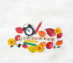 September time. stationery, pencil, alarm clock, flowers, autumn leaves. education, starting school, back to school Concept. symbol of 1 september, beginning of school year. flat lay.