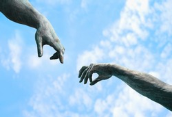 two hands, fragment of old statue. hands reaching each other with fingers against blue sky, natural background. touch, contact, art minimal symbol. Creation of Adam metaphor by Michelangelo