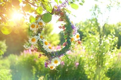 wreath of wild Meadow flower in summer garden. Summer Solstice Day, Midsummer concept. floral traditional decor. pagan witch traditions, wiccan symbol and rituals