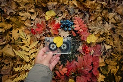 retro audio cassette in hand, autumn natural background. atmosphere image of autumn music. inspiration, melody, nostalgia concept. fall season