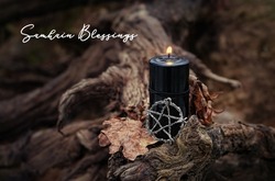 Samhain Blessings. Pentagram amulet and black candle in autumn forest. Magic esoteric witches ritual. Mysticism, divination, wicca, occultism, witchcraft concept. Samhain sabbat