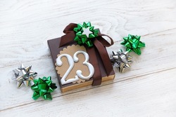gift box with 23 number and festive bows on white wooden background. 23 february holiday, Fatherland defender day concept. gift for man, brutal style. top view