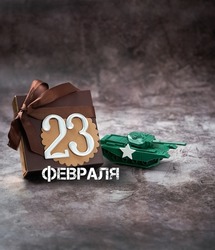 gift box with bow, tank toy and 23 february russian text on abstract dark background. Present for day of defenders of fatherland, 23 february holiday concept. gift for man