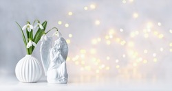 Praying angel figurine and snowdrops flowers on table, abstract background. Religious church holiday. symbol of faith in God, christianity. Easter, Feast of Annunciation to the Blessed Virgin Mary