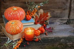 autumn still life. pumpkins, autumn leaves and old books on wooden background. fall season, thanksgiving holiday, Halloween concept