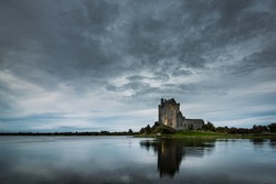 Old Irish Dunguaire Castle near the water in the evening with reflection