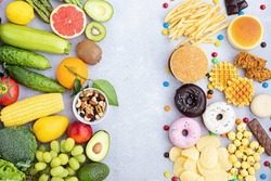 Flat lay of Healthy and unhealthy food from fruits and vegetables vs fast food, sweets and pastry on gray concrete background. Diet and detox against calorie and overweight lifestyle concept.