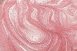 Pink liquid shimmering cosmetic product studio shot.