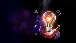 Businessman holding a bright light bulb. Concept of Ideas for presenting new ideas Great inspiration and innovation new beginning. Futuristic tone purple, neon color. Analyzing data