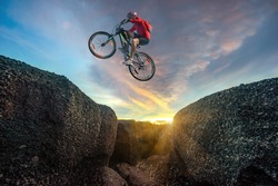 Professional rider is jumping on the bicycle, with background of sunset, racing in high speed competition