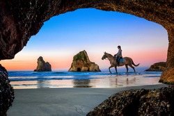 view from the cave of Wharariki Beach with house rider, the place popular for tourist travel in summer, vacation and holidays, locate in topest of South new Zealand