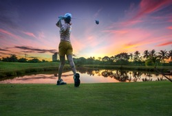 a woman golf player in an action of ene of downswing after hit the golf ball away from tee off to the fairway ahead by wood driver