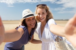 two girls taking a selfie on the beach