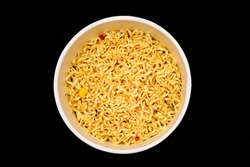 Instant Noodles in Disposable Cup on Black Background - Top View. Asian Fast Food. Quick Lunch