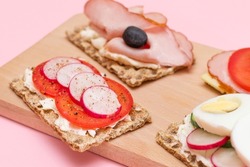 Different Whole Grain Crispbread with Ham, Tomato, Radish, Cucumber and Cheese. Easy Breakfast. Diet Food. Quick and Healthy Sandwiches. Crispbread with Tasty Filling. Healthy Dietary Snack