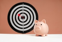 piggy bank in front of dartboard concept of saving money with a goal