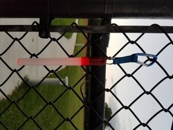 pink or red glowstick handing on metal fence