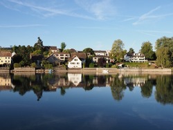 Houses at Rhine River in european STEIN AM RHEIN town in SWITZERLAND, canton Schaffhausen, clear blue sky in 2018 warm sunny summer day on August.