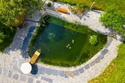 Garden pond. Relaxation zone with fish farming in an organic orchard from above. Sustainable development in gardening and aquaculture.