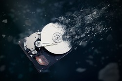 The old hard disk drive is disintegrating in space. Conception of passage of time and obsolete technology
