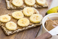Healthy vegan snack with scandinavian rye crispbread, homemade peanut butter and slices of Canary island bananas