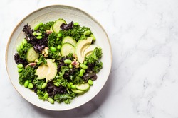 Green and purple kale salad with beans, avocado and cucumber. Healthy vegan food concept.