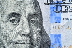 Dolar USA close up. Franklin eyes macro. The texture of the fragment of the dollar bill. USD banknote texture. One hundred American dollars. $ 100.