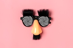 funny face - fake eyeglasses, nose and mustache on pink background Happy fools day  concept  1st April party Holiday card