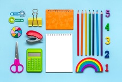 Frame from school and office supplies Paper clips, pens, calculator, sharpener, notepad, stapler isolated on blue background Flat lay Top view Back to school, education concept Mock up Copy space