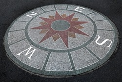 fragment decorative compass points with north, south, east, and west on the cement ground