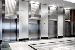  modern steel elevator cabins in a business lobby