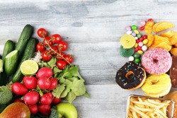 healthy or unhealthy food. Concept photo of healthy and unhealthy food. Fruits and vegetables vs donuts,sweets and burgers on dark