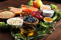 Healthy food clean eating selection: fish, fruit, vegetable, cereal, leaf vegetable on background