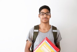 Happy afro american student in glasses with books. Portrait of a black young man with textbooks in his hands. Smiling boy with a backpack and notebooks on a white background. The concept of education.