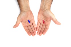 Red and blue pills on hand isolated on white background. They represent the choice between embracing the truth and reality, red or blissful ignorance, blue