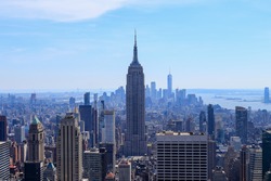 Aerial view of downtown Manhattan with Empire State Building and statue of liberty in the far view. Empire State Building is a 102 skyscraper located on Fifth Avenue between West 33rd and 34th Streets
