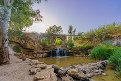 View of the ancient Kantar bridge, over the Harod Stream, with Eucalyptus trees, in the Lower Jordan River valley, Northern Israel