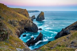 The coastline of Cornwall, England. A summers evening and the sky is glowing as the sun sets over the spectacular, rugged coastline