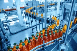 Conveyor belt, juice in bottles on beverage plant or factory interior in blue color, industrial production line, toned