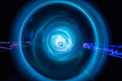 Round plasma laser flashes and fast rotation storm movement as abstract neon electric tunnel background