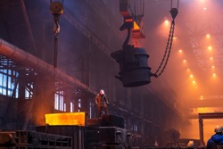 Big ladle on crane before melting in foundry workshop. Smelting of multi-ton cast iron parts. Metallurgical plant or Steel Mill