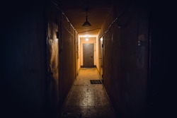 Dirty empty dark corridor in apartment building, doors, lighting lamps, perspective, in yellow-orange tones, copy space