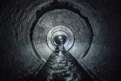 Diggers are exploring underground river flowing in round sewer tunnel